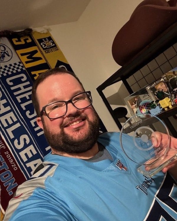 Ben Smith of R+L Global, 2025 Freight Fantasy Football champion, holding the Transfix trophy.